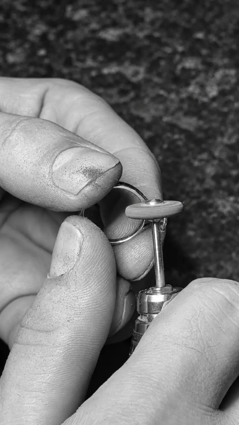 Detailed ring finishing at the workshop bench, photographed in black and white